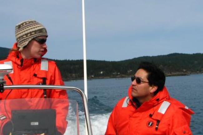 Alejandro and a student talking while on a boat